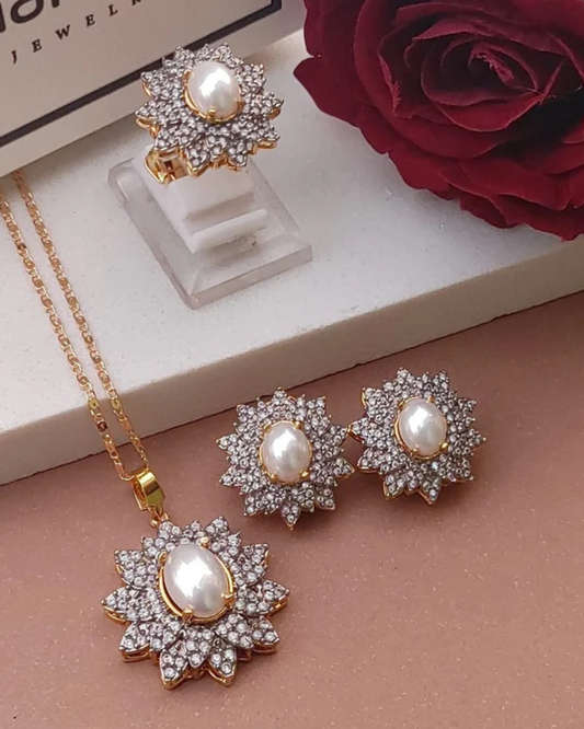 Jewelry set with necklace and earrings featuring pearls and zirconia stones on a beige surface.